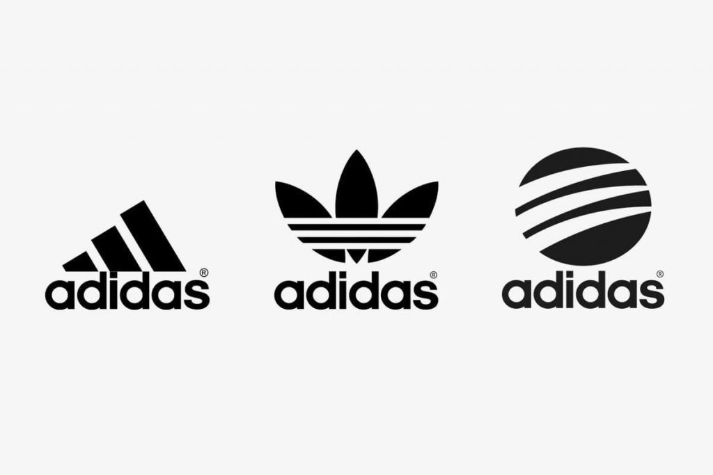 Na slici su tri verzije Adidas znakova, logo sa tri linije koje kreiraju trokut sa riječima Adidas ispod. Drugi izgleda kao polovina cvijeta, i prepoznatljive tri linije preko sredine. Treći logo je u obliku lopte sa tri linije. Sva tri loga su u crno-bijeloj kombinaciji. 